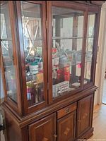 Front view of the two-piece solid wood hutch showing glass display doors and lower solid wood cabinet doors.