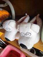 Top view of white plush Family Guy Brian dog slippers showing face details and shape