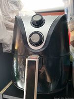 Front view of Insignia food maker air fryer showing black and silver body with two control dials.