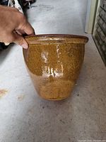 Side view of the brown glazed ceramic planter showing texture and glossy finish