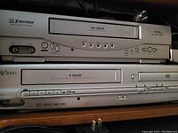 Photo of a silver Emerson VHS VCR and SV2000 DVD player stacked.