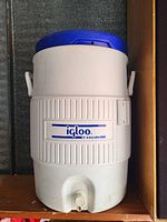 Photo of white Igloo 5-gallon water cooler with blue lid and front spigot.