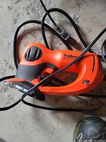 Orange and black Black & Decker ZipSaw electric handheld saw with cord coiled around it.