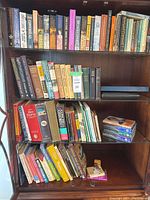 Shelf with mixed paperback and hardcover books, visible titles include historical, fiction, and other genres.