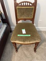 Front view of the olive green velvet and maple wood Eastlake chair showing detailed wood carvings and seat upholstery with dimensions labeled.