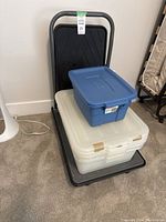 Front view of dolly holding two storage bins, blue on top, white below.