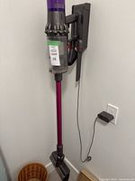 Assembled vacuum mounted on wall dock with charger cable connected