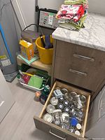 Photo of step stool, bucket, cleaning supplies, and hand towels on and around a counter in a room corner