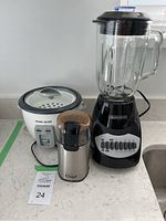 Front view of the three small kitchen appliances: Black and Decker blender, rice cooker, and Master Chef grinder.