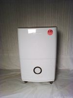 Front view of white rectangular dehumidifier body with a circular handle on the water tank and a sticker marked '173'