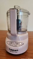 Front view of pink Cuisinart Mini-Prep Plus food processor showing base with buttons, transparent work bowl and lid.