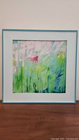 Front view of framed square oil painting with pastel floral abstract art and light blue wooden frame.