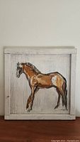 Frontal photo showing full view of the painting of horse on wooden panel with signature visible