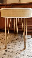 Close-up photo of gold metal hairpin legs and jute trim side of the table.
