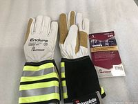 Pair of gloves showing front and back with black and yellow striped protective sleeves and white and tan buffalo leather palms and fingers.