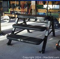 Side view photo of Core Strength fitness system bench with three padded step platforms in gym setting showing used condition and sturdy metal frame.