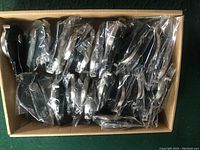 Top view of a box containing multiple individually packaged clip-on belt watches wrapped in plastic bags.