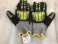 Top view of a pair of gray, yellow and black MAPA Professional Grip & Proof gloves with visible protective padding and textured grip.