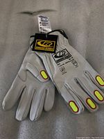 Full view of the white Ringers Gloves with yellow and red protective pads on finger joints, showing front palm side and design details.