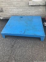 Top view of blue steel platform with worn surface and some rust stains