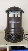Front view of the Dynatrap XL bug trap showing the brand logo and the full body design, dark brown with mesh lower section.