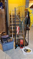 Full view of fishing rods, reel, net, jacket, tackle bag, and accessories grouped together for lot inventory.