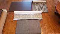 Five assorted floor mats and runners laid out on hardwood floor showing variety in patterns, colors, and sizes.