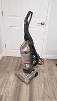 Front angle view of Hoover Windtunnel upright vacuum cleaner showing overall condition, handle, base, and cord.