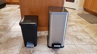 Both trash cans side by side showing size difference and materials.