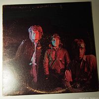 Front cover of Fresh Cream LP vinyl record showing the band members in warm jackets under dim lighting with edge wear visible.