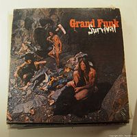 Front of the Grand Funk Railroad Survival album cover showing cave scene artwork with band members. Moderate edge wear and corner damage.