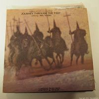 Front cover of the vinyl record showing a blurred image of knights on horseback with crosses, titled 'Journey Through The Past' by Neil Young. Indicating a double record set.