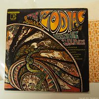 Front cover of The Zodiac Cosmic Sounds vinyl LP showing colorful psychedelic zodiac-themed artwork and Elektra Records logo in upper left.