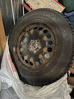 Photo of one winter tire mounted on black steel rim showing size and general condition.