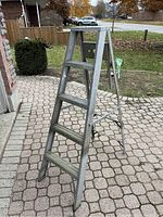 5-step aluminum A-frame ladder standing open on patio