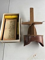 Wooden stereograph viewer next to a box holding multiple antique stereograph cards.