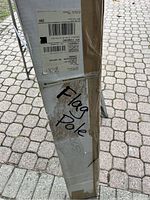 Cardboard rectangular box labeled with 'Flag Pole' handwritten on side, showing packaging is intact and the item is new.