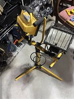 Photo showing the dual head halogen work light on the tripod with handles and cords visible.