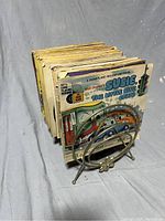 Stack of vintage Disney story and record books with wear, with metal record stand in front