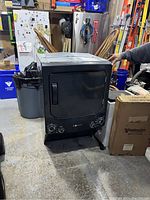Overall view of charcoal stacked washer/dryer combo unit in garage.