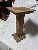 Side view of vintage wooden side table showing square top, pillar-style central support, and square base.