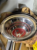 Close-up image of one chrome Willys hubcap with red circular center featuring white and chrome 'W' logo and concentric chrome rings.