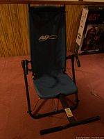 Front view of one AB Lounge 2 chair showing blue fabric seats, black frame, and foam arm handles