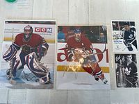 Four autographed hockey photos laid out on a table, showing players in action and close-ups of signatures.
