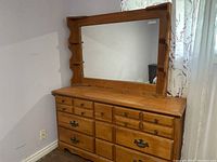 Front view of solid wood bedroom dresser with attached mirror, showing its drawers and wood finish.