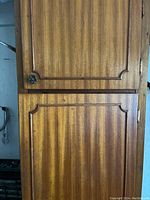 Closed wooden cabinet with dark wood veneer finish and decorative knob