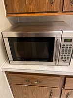 Front view of stainless steel microwave with control panel and handle