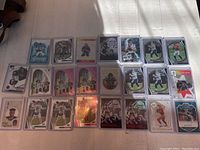 Overview of all 23 football rookie cards spread on a surface, showing a mix of players and card styles, including special editions.