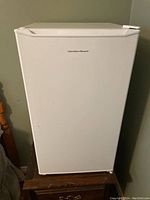 Front view of white compact fridge with Hamilton Beach logo.
