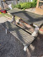 Outdoor bench and table converted to table mode showing weathered wood and metal frame.